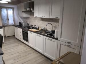 a kitchen with white cabinets and a sink at Civico 46 in Abbadia San Salvatore
