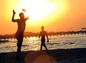 dos hombres jugando con un frisbee en la playa en Hotel Mango Cafe, en Tela