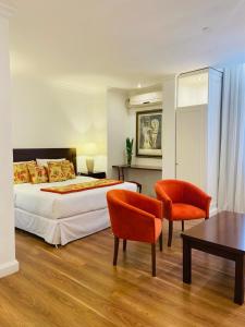 um quarto com uma cama, 2 cadeiras e uma mesa em Gran Texier Hotel Casino em Concepción del Uruguay