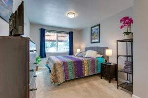 a bedroom with a bed and a tv and a window at Cozy Denver Home with Hot Tub, 2 miles to Dtwn! in Wheat Ridge