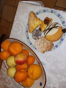 dos platos de comida en una mesa con frutas y repostería en Agriturismo Vemi, en Santa Sofia dʼEpiro