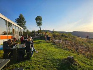 a group of people sitting at a table on a hill at Bergen Hostel Montana in Bergen
