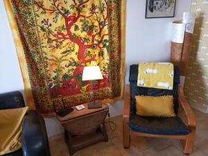 a room with a chair and a tapestry on the wall at Volets Verts in Montauriol