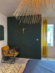 een slaapkamer met een klok op een groene muur bij Anse margot in Baie Nettle