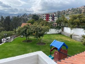 un parque infantil con un banco azul en un patio en Quinta Hotel Las Buganvillas, en Ambato