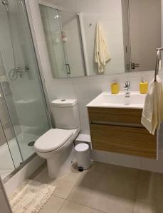 a bathroom with a toilet and a shower and a sink at Departamento Vista Privilegiada in Concepción