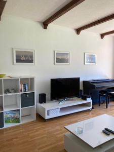 a living room with a flat screen tv and a piano at Ferienwohnung Seefelder in Füssen