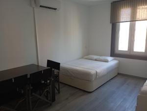 1 dormitorio con cama, escritorio y ventana en Estudio en Callao, 4 personas, en Madrid