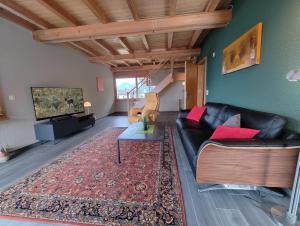 a living room with a black leather couch and a television at Traumhafte Villa Seelisberg in Seelisberg