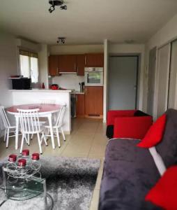 een woonkamer met een bank en een tafel en een keuken bij Charmant T2 Dans Petite Résidence in Font Romeu Odeillo Via