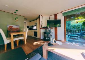 a living room with a dining table and a kitchen at "De Jungle" Chalet met veranda op IJsselheide Hattemerbroek Veluwe in Hattemerbroek