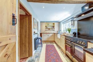 a kitchen with wooden cabinets and a stove top oven at The Bolthole in Nuneham Courtenay