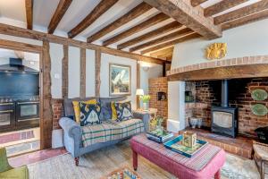 a living room with a couch and a fireplace at The Bolthole in Nuneham Courtenay