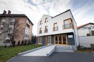 a white building with stairs in front of it at MERKUR APARTMENTS in Miercurea-Ciuc