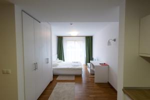 niewielka sypialnia z łóżkiem i oknem w obiekcie MERKUR APARTMENTS w mieście Miercurea-Ciuc