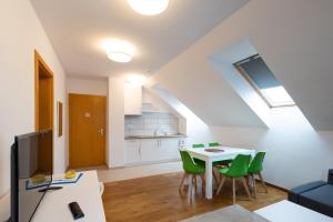 a living room with a white table and green chairs at MERKUR APARTMENTS in Miercurea-Ciuc