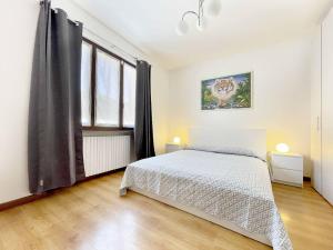 a bedroom with a bed and a large window at Il Gatto e la Tartaruga Appartamento in Grignasco