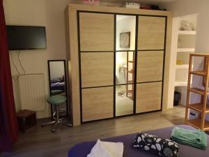 a room with a large wooden cabinet with a mirror at Insolite 20 in Chambéry