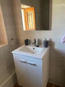 uma casa de banho com um lavatório branco e um espelho. em Casa Tomas em Albox