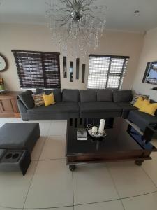 een woonkamer met een bank en een tafel bij The Executive 5 Bedroom in Manzini