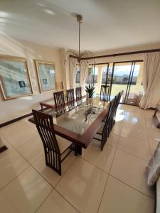 uma sala de jantar com uma mesa de madeira e cadeiras em The Executive 5 Bedroom em Manzini
