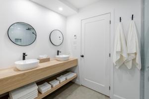 a bathroom with two sinks and a mirror at SOFA VILLAS MONT SAINTE-ANNE in Beaupré