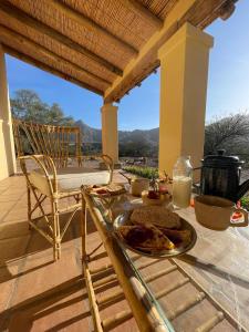 a table with a plate of food on a patio at Hospedaje Finca la Encantada in Seclantás