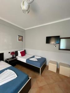 a hotel room with two beds and a tv at Hotel&Restaurant Aroma in Përmet