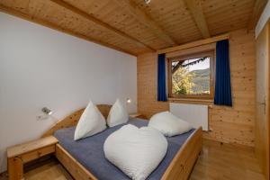 a bed in a wooden room with a window at Tendershof Reschen in Resia