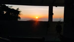 a sunset seen through the window of a house at Casa na praia de Setiba com panorama fantástico in Guarapari