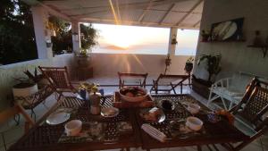 a table and chairs on a patio with a view of the ocean at Casa na praia de Setiba com panorama fantástico in Guarapari