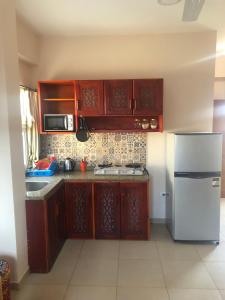 - une cuisine avec des placards en bois et un réfrigérateur blanc dans l'établissement Dahab Relax Studio 3, à Dahab