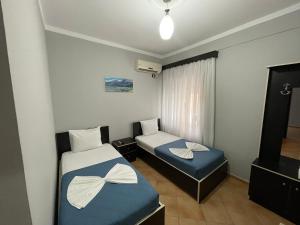 a small room with two beds and a window at Hotel&Restaurant Aroma in Përmet