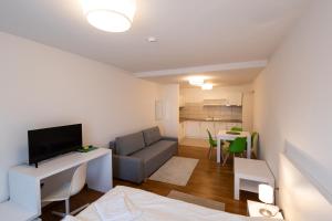a living room with a couch and a television at MERKUR APARTMENTS - SELF CHECK-in in Miercurea-Ciuc +8 photos