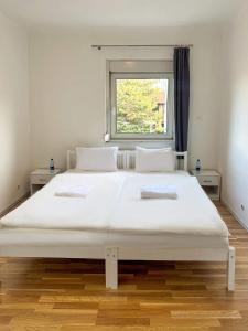 een groot wit bed in een kamer met een raam bij Adelin Vienna in Wenen