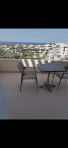 a table and chairs on a balcony with a view at Appartement panorama in Tunis