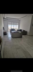 a large living room with couches and a tile floor at Appartement panorama in Tunis