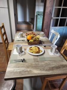 una mesa con un plato de comida y una cesta de fruta en La Casa El Cura, en Madrigal de la Vera