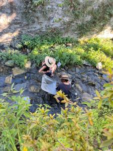 Dos personas están sentadas en las rocas cerca de un río. en Monster B&B, en Dali