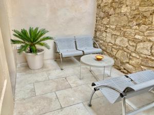 馬賽的住宿－JoliJoliette, terrasse, central, climatisé, WIFI , garage，庭院设有两把椅子和一张桌子,还有植物