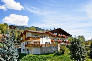 a large white building with balconies on a hill at Pension Volgger in Rodengo