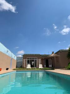 una piscina frente a una casa en Escape to Luxury Moroccan Villa with Pool Garden and Endless Sunshine Book Your Blissful Getaway Now, en Sidi Bibi