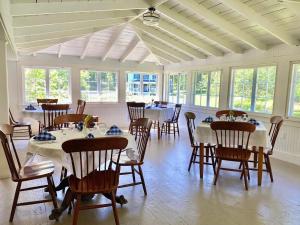 BrooksvilleにあるOakland House Seaside Inn & Cottagesのテーブルと椅子、窓が備わる広い客室です。