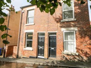 un edificio de ladrillo con puertas negras en una calle en Potters Cottage en Sheffield