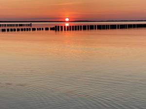 a sunset over a body of water with a pier at Ferienhaus Stella in Glowe