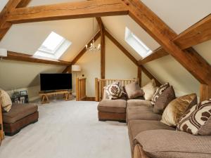 a living room with two couches and a flat screen tv at Cuckoo Penn Hideaway in Stonehouse