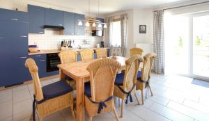a kitchen with a wooden table and chairs at Ferienhaus Stella in Glowe