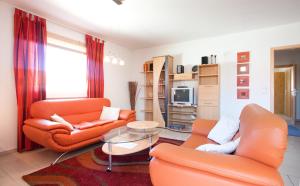 a living room with two orange chairs and a table at Ferienhaus Stella in Glowe