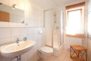 a bathroom with a sink and a toilet and a shower at Ferienhaus Stella in Glowe