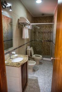 a bathroom with a toilet and a sink and a shower at Hotel FK Paso de los Toros - Hotel Boutique in Paso de los Toros
